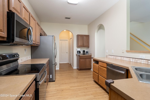 kitchen with light hardwood / wood-style floors, sink, and stainless steel appliances