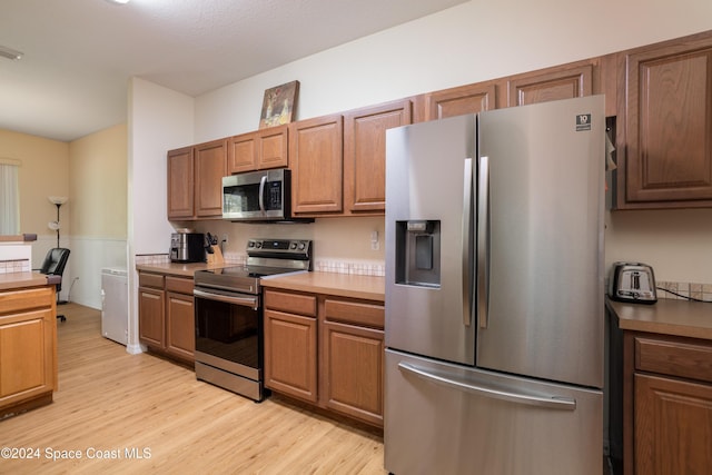 kitchen with stainless steel appliances and light hardwood / wood-style floors