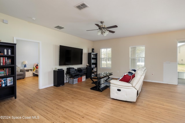 living room featuring light hardwood / wood-style flooring and ceiling fan