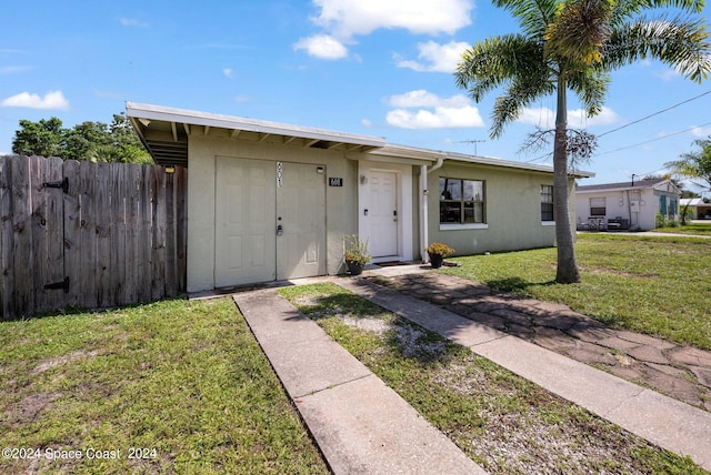 single story home with a front lawn