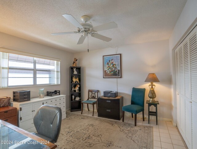 tiled office with ceiling fan and a textured ceiling