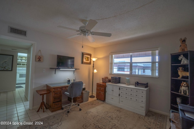 office area featuring ceiling fan, light tile patterned floors, and a textured ceiling