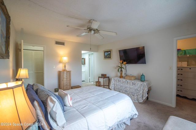 carpeted bedroom featuring connected bathroom and ceiling fan