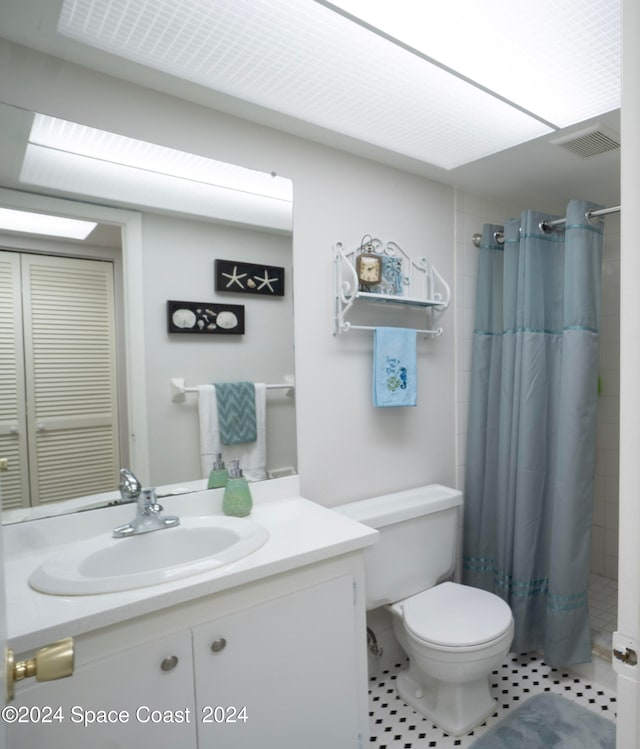 bathroom with vanity, tile patterned floors, toilet, and curtained shower