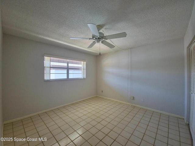 spare room featuring a textured ceiling, baseboards, and ceiling fan
