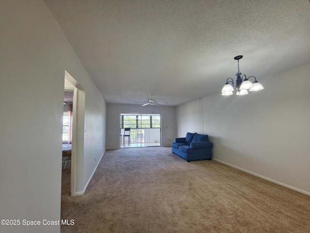 unfurnished room with carpet flooring, ceiling fan with notable chandelier, baseboards, and a textured ceiling
