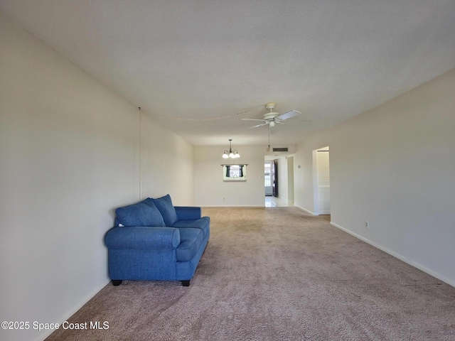 interior space featuring carpet floors, baseboards, and ceiling fan with notable chandelier