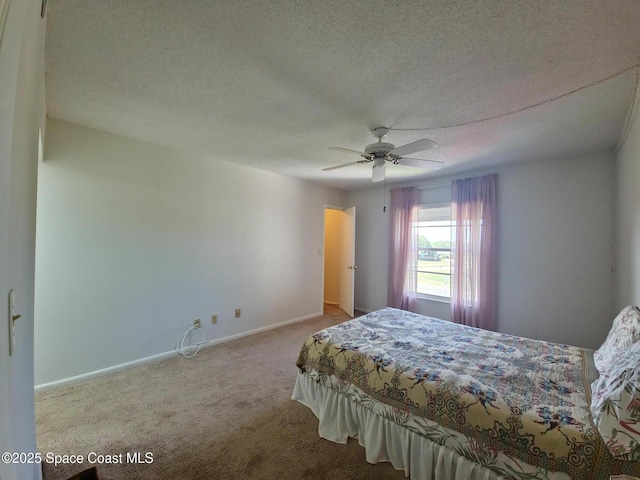 bedroom with a textured ceiling, baseboards, a ceiling fan, and carpet floors