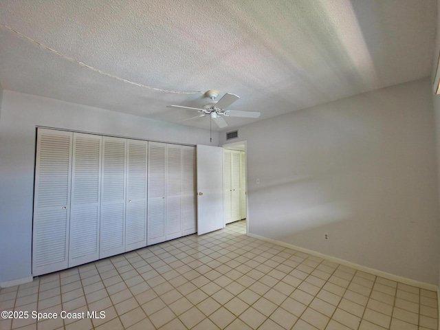 unfurnished bedroom featuring a closet, baseboards, visible vents, and a textured ceiling