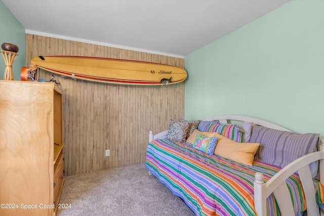 bedroom featuring carpet floors, wood walls, and crown molding