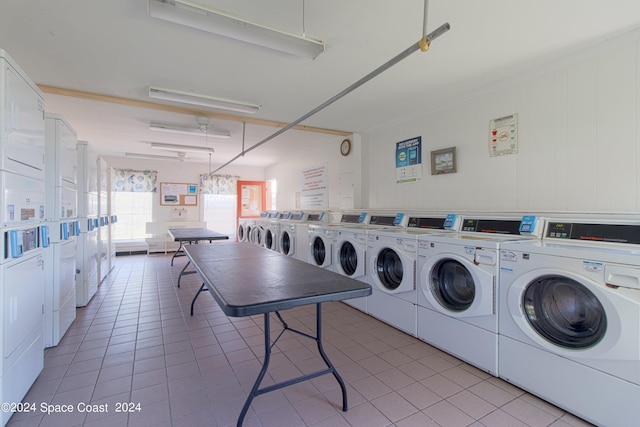 laundry area with stacked washer and clothes dryer, washing machine and dryer, and light tile patterned floors