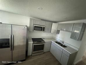 kitchen with gray cabinets, stainless steel appliances, dark hardwood / wood-style floors, and sink