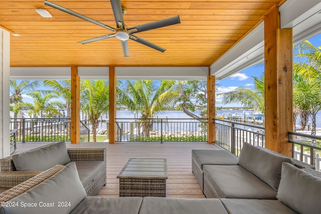 exterior space with ceiling fan, outdoor lounge area, and a deck with water view