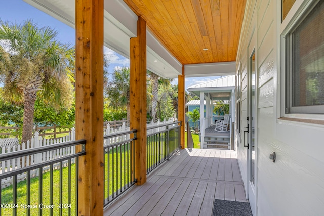 wooden terrace featuring a lawn