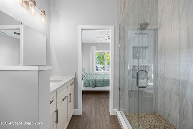 bathroom featuring ceiling fan, vanity, a shower with door, and hardwood / wood-style flooring