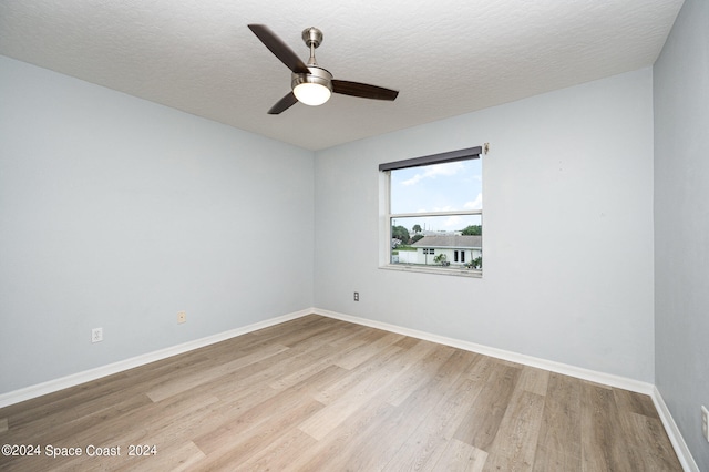 empty room featuring light wood-type flooring, ceiling fan, and a textured ceiling