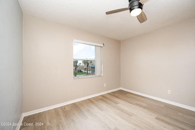 unfurnished room with a textured ceiling, light hardwood / wood-style floors, and ceiling fan