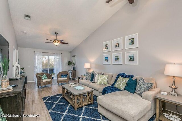 living room with light wood-type flooring, lofted ceiling, and ceiling fan