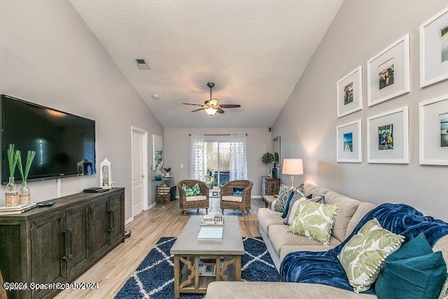 living room featuring light hardwood / wood-style floors, lofted ceiling, and ceiling fan