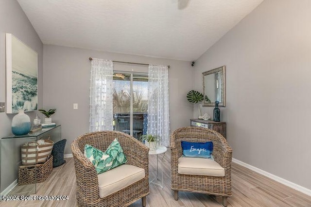 living area featuring vaulted ceiling and light hardwood / wood-style flooring