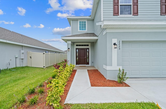 doorway to property featuring a lawn and a garage