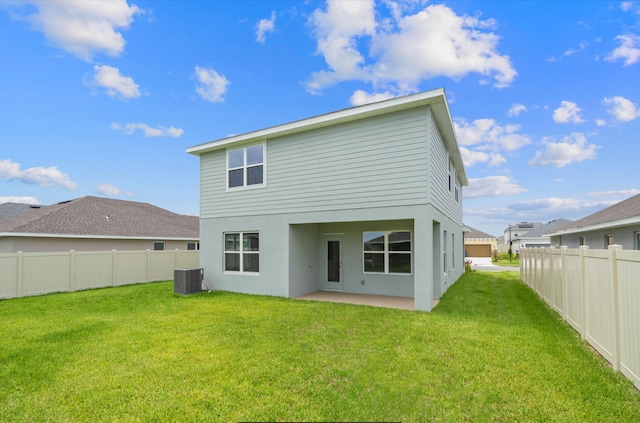 rear view of house with a lawn, a patio, and central air condition unit