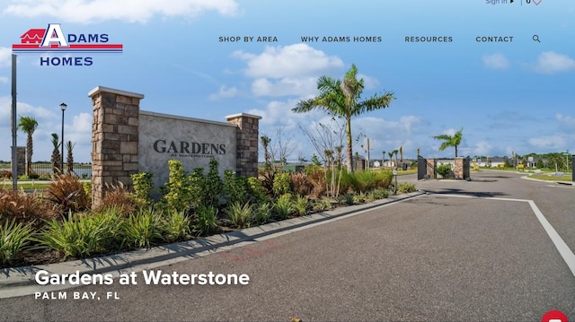 view of street featuring a gated entry and curbs