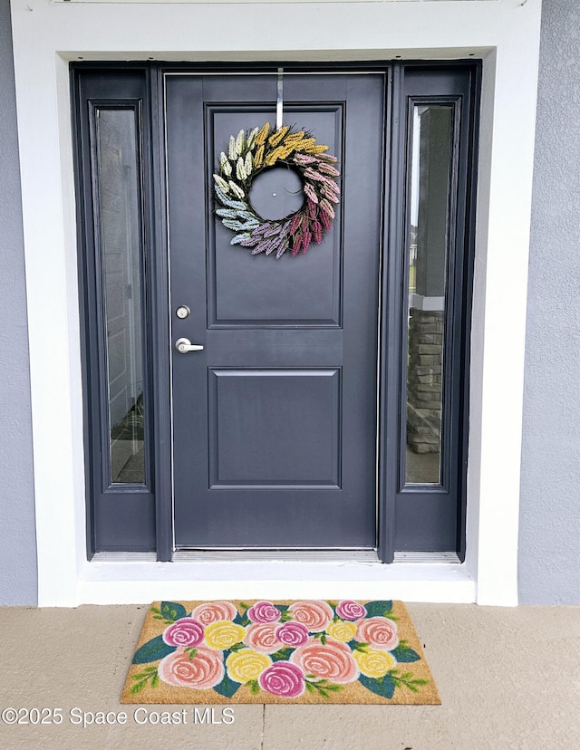 property entrance featuring stucco siding