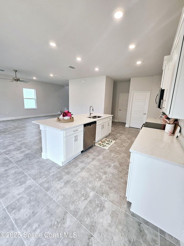 kitchen with a sink, dishwasher, open floor plan, and white cabinetry