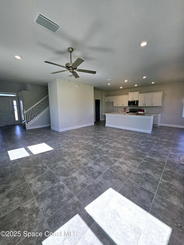 unfurnished living room featuring visible vents, baseboards, stairway, recessed lighting, and a ceiling fan