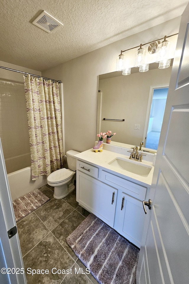 bathroom featuring vanity, toilet, visible vents, and a textured ceiling