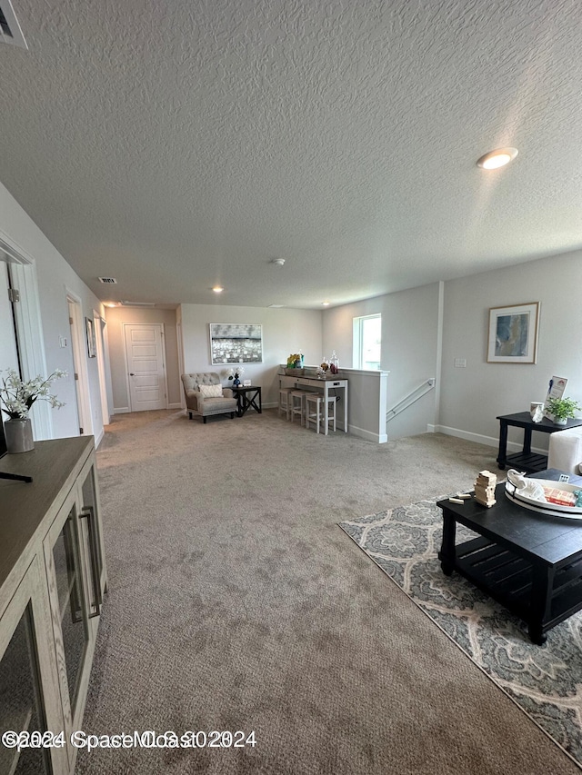 carpeted living room featuring a textured ceiling