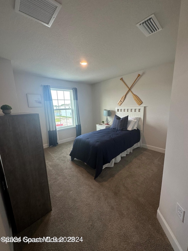 carpeted bedroom featuring a textured ceiling