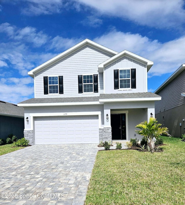 view of front of house with a front lawn, a garage, stone siding, decorative driveway, and board and batten siding