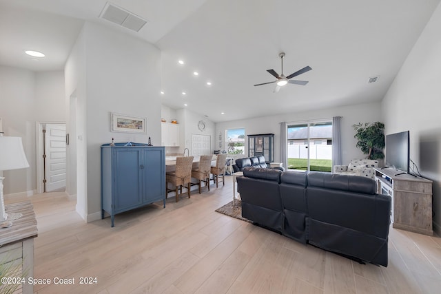 living room featuring ceiling fan, light hardwood / wood-style flooring, and high vaulted ceiling