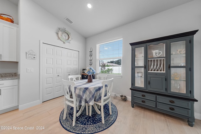 dining space featuring lofted ceiling and light hardwood / wood-style floors