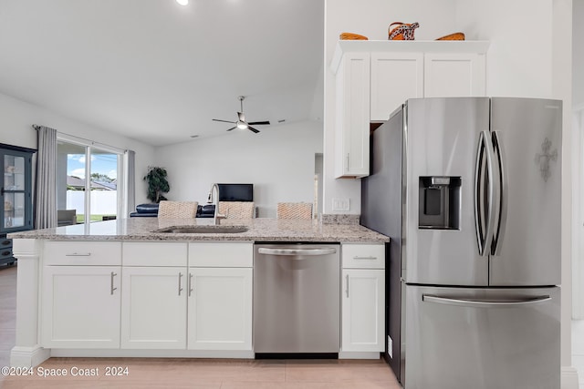 kitchen with stainless steel appliances, vaulted ceiling, white cabinetry, and sink