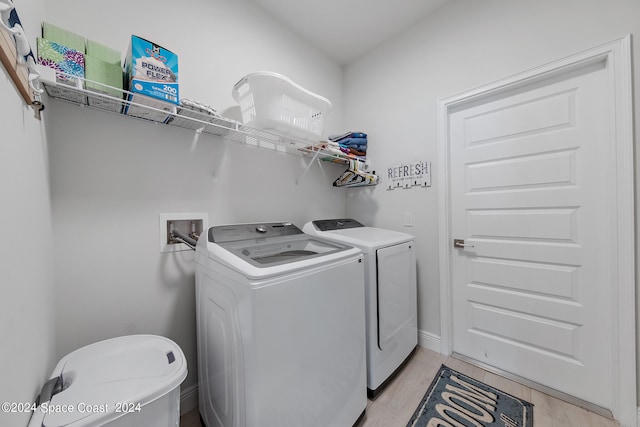 laundry area with light hardwood / wood-style flooring and separate washer and dryer