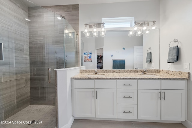 bathroom featuring a shower with door and vanity