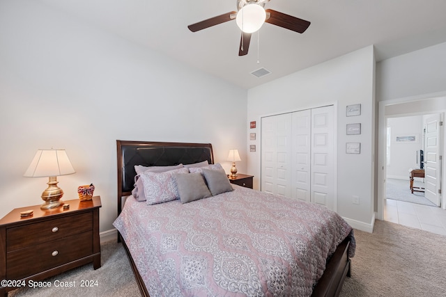 carpeted bedroom with ceiling fan and a closet