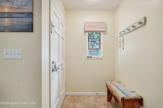 entryway featuring light tile patterned flooring and a textured ceiling