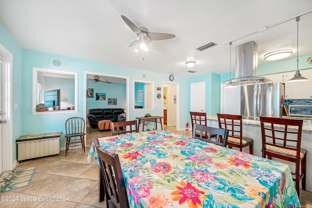 dining area featuring light tile patterned floors, radiator heating unit, a textured ceiling, and ceiling fan