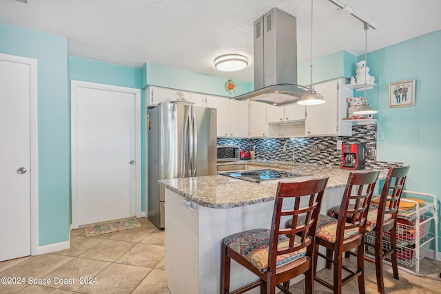 kitchen featuring island exhaust hood, stainless steel fridge, kitchen peninsula, pendant lighting, and white cabinets