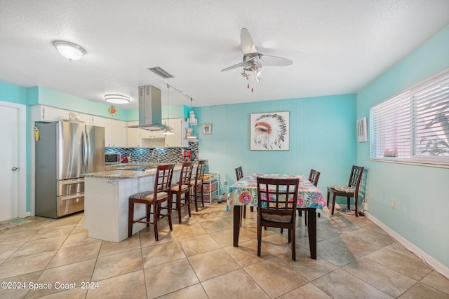 dining room with light tile patterned floors, a textured ceiling, and ceiling fan