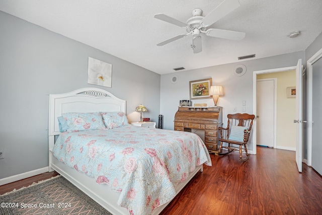 bedroom with ceiling fan, dark hardwood / wood-style floors, and a textured ceiling