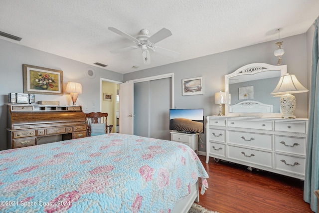 bedroom with a textured ceiling, a closet, dark hardwood / wood-style floors, and ceiling fan