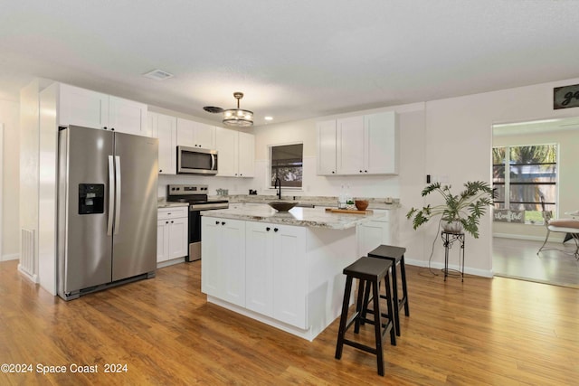 kitchen featuring stainless steel appliances, white cabinetry, and light wood-type flooring