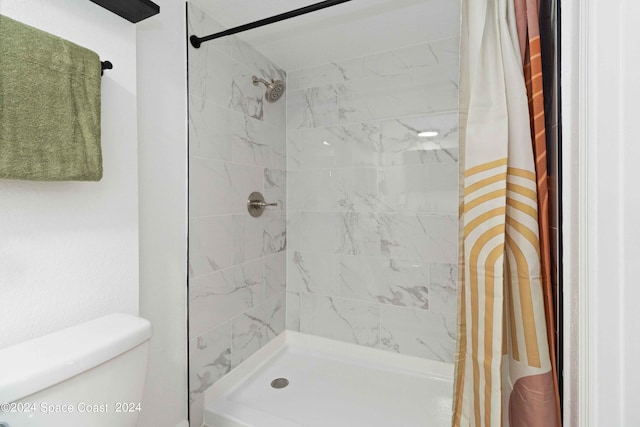 bathroom featuring toilet and a shower with shower curtain