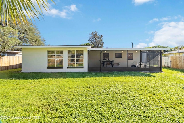 back of property with a lawn and a sunroom