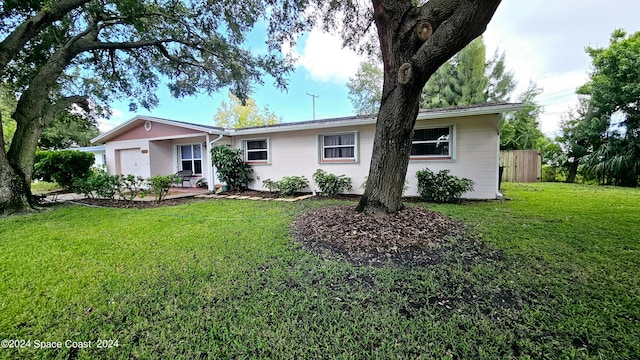 ranch-style home with a garage and a front yard